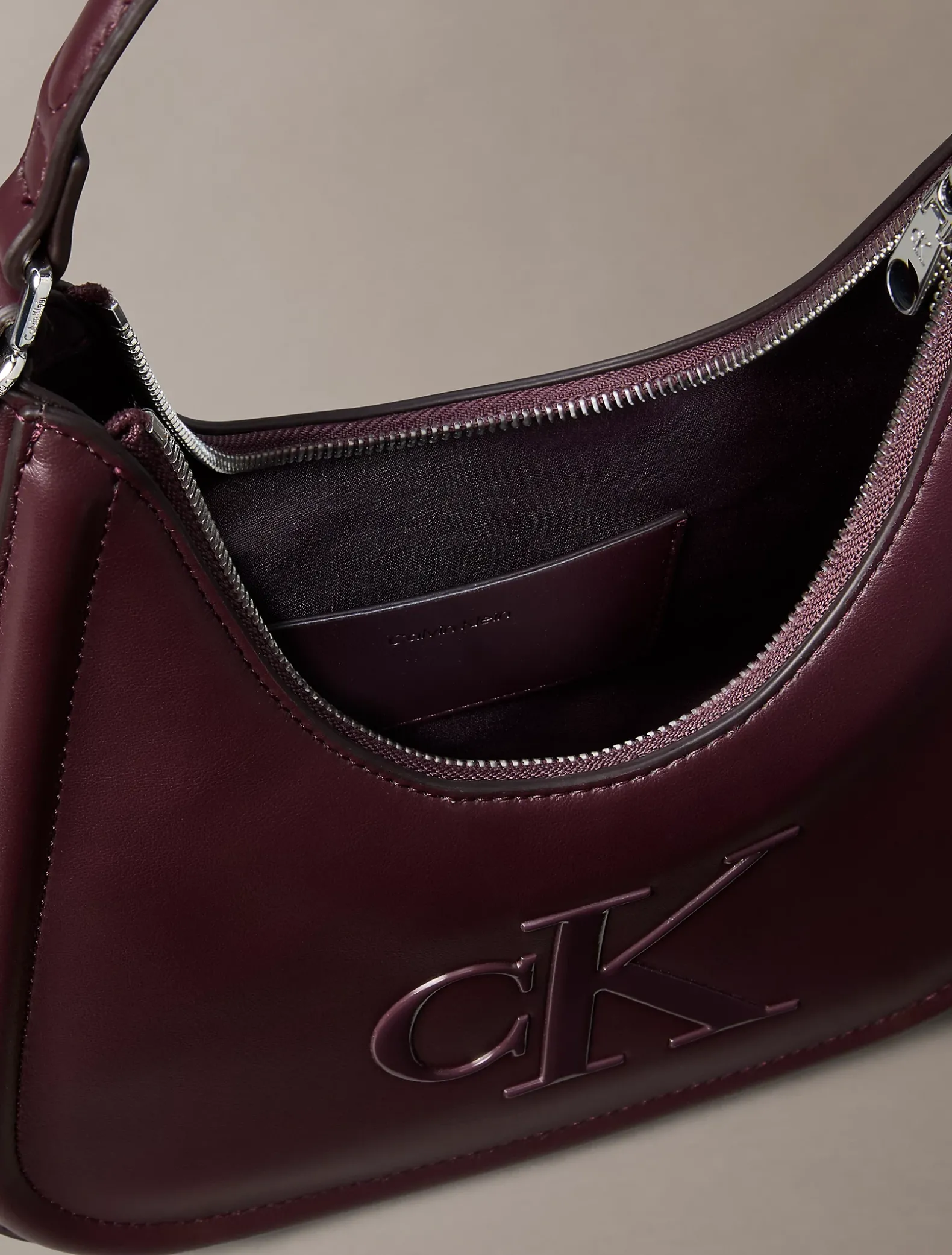 Maanvormige tas met monogram in reliëf